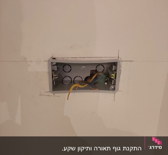 תיבת חשמל פתוחה עם חוטים חשמליים חשופים